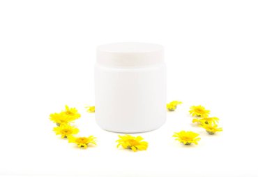 Krem, merhem, maske ve küçük sarı papatya beyaz bir arka plan üzerinde beyaz mocap. Ayrı tutma, yakın çekim, açık görünüm
