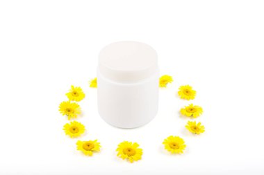 Krem, merhem, maske ve küçük sarı papatya beyaz bir arka plan üzerinde beyaz mocap. Ayrı tutma, yakın çekim, açık görünüm