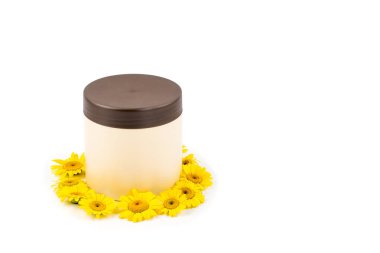Kahverengi kapak, krem, merhem, maske ve beyaz bir arka plan üzerinde küçük sarı papatyalar mocap bej kavanozu. Ayrı tutma, yakın çekim, açık görünüm