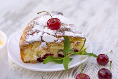 Beyaz tabak yakın tarihinde kirazlı turta nefis bir parça. Yaz yiyecek. Güzel kokulu nane Şubesi