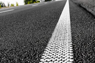 Yeni siyah asfalt yol ve bölen çizgiler beyaz noktalar üzerinden. Asfalt dokusal arka plan.