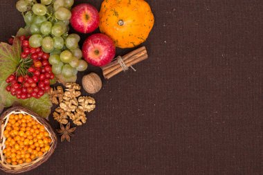 Sonbaharın vitaminler. Çilek ve kahverengi kumaş arka plan, üstten görünüm üzerinde kartopu, Deniz topalak, kabak, ceviz, kırmızı elma, üzüm, tarçın ve anason yaprak. Alan, duygusuzca kopyalama