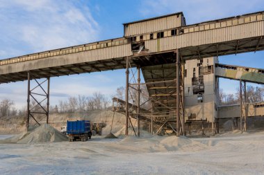Sarı Ekskavatör kova içine büyük bir yığın moloz toplar ve kamyonun içine dökülen. Taş ocağı, madencilik ve taş sürtünme.