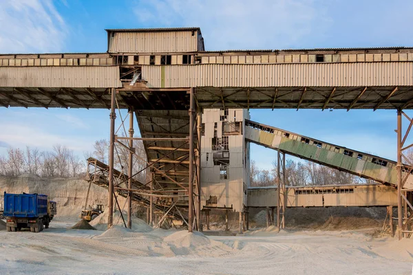 Sarı Ekskavatör kova içine büyük bir yığın moloz toplar ve kamyonun içine dökülen. Taş ocağı, madencilik ve taş sürtünme.