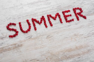 Ahududu meyveleri dokulu bir ışık ahşap arka plan üzerinde yazıt yaz yapılmış. Düz üst görünümü, metin için yer. Yat, alanı Kopyala.