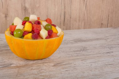 Meyve salatası. Şeftali, karpuz, kavun, ahududu, Erik, üzüm, kavun Beyaz ahşap zemin üzerinde bir salata kaseye doğranmış yalan. Metin için yer. Uzay kopyalayın, şu görüntüleme