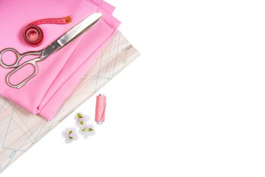 Dikiş. Dikiş ve iğne işleri için dikiş aksesuarları ve aksesuarları. Makas, santimetre, desen, iplik makara ve beyaz bir arka plan üzerinde pembe renk kumaş. İzole, Düz Lay, Kopyalama Alanı