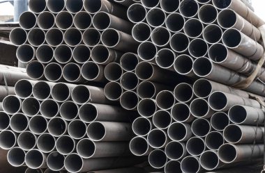 Metal rolling. A round tube are stacked in storage for sale and loading in stock. View from the front, end view, close-up.