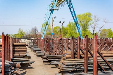 Metal rolling. A round tube are stacked in storage for sale and loading in stock in the open air.
