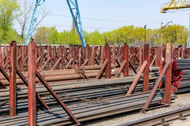 Metal rolling. A round tube are stacked in storage for sale and loading in stock in the open air.