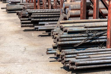 Metal rolling. A round tube are stacked in storage for sale and loading in stock in the open air.
