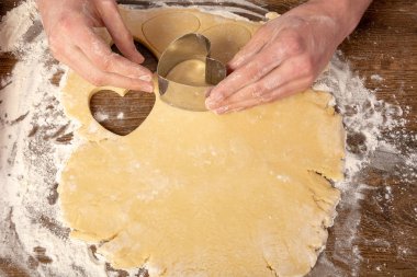 Kalp şeklinde kurabiye pişirmek. Sevgililer günü, tatil için kurabiye pişirmek. Metin, üst görünüm, düz döşeme, kopyalama alanı için yer