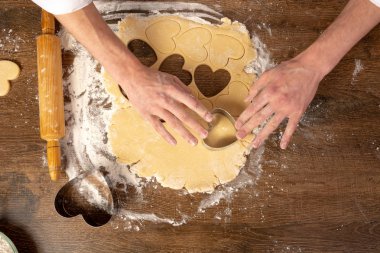 Kalp şeklinde kurabiye pişirmek. Sevgililer günü, tatil için kurabiye pişirmek. Metin, üst görünüm, düz döşeme, kopyalama alanı için yer