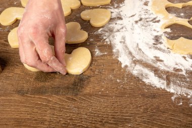 Kalp şeklinde kurabiye pişirmek. Sevgililer günü, tatil için kurabiye pişirmek. Metin, üst görünüm, düz döşeme, kopyalama alanı için yer