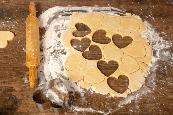 Cooking cookies in the shape of a heart. Valentine's day, baking cookies for the holiday. Place for text, top view, flat lay, copy space