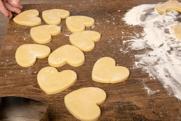 Cooking cookies in the shape of a heart. Valentine's day, baking cookies for the holiday. Place for text, top view, flat lay, copy space