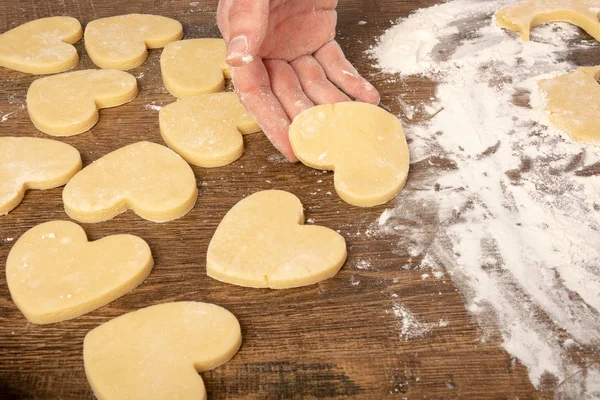 Cooking cookies in the shape of a heart. Valentine's day, baking cookies for the holiday. Place for text, top view, flat lay, copy space