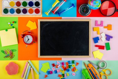 İlkokul çocuklarına eğitim. Genel konuların incelenmesi için kırtasiye aksesuarları ile parlak ve çok renkli okul arka plan. Düz Lay, Kopya alanı, Mock up, üst görünüm, metin için yer.