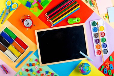 Okul hazırlık ve ilkokulda çocukların eğitimi. Genel konuların incelenmesi için kırtasiye aksesuarları ile parlak ve çok renkli okul arka plan. Düz Lay, Kopya alanı, Mock up, üst görünüm, metin için yer.