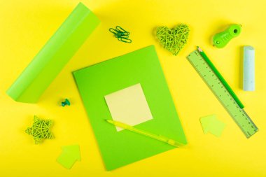 Okula geri dönelim, okul geçmişi. Yeşil Mock kadar egzersiz kitabı ve ders kitabı okul konuları ve sarı bir arka plan üzerinde kırtasiye için. Düz düzen, kopyalama alanı, üst görünüm, metin için alan.