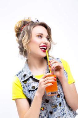 Mutlu bir hayat fikirler ve kavramlar. Portakal suyu ve saman ile poz iyimser ve mutlu Beyaz sarışın bir kız. Denim yelek giyiyor. White.Vertical görüntü karşı