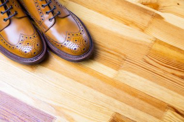 Ayakkabı fikirler ve kavramlar. İpuçları erkeğin Brooge çizme Tan renkli closeup. Ahşap sarımsı Background.Horizontal görüntü üzerinde duran