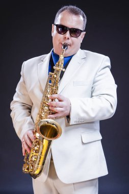 Müzik Temalar ve fikirler. Siyah Background.Vertical görüntü kompozisyon karşı sakin beyaz olgun saksofoncu