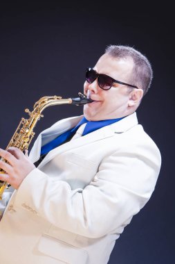 Müzik kavramları. Güneş gözlüğü Sax. siyah arka plan ile poz ifade olgun oyun saksofoncu. Dikey görüntü kompozisyon