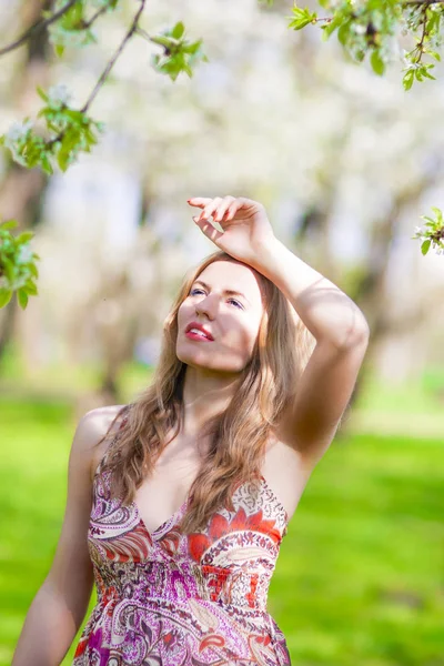 Yaşam tarzı kavramları. Seksi ve şehvetli rahatlatıcı yaz Park açık havada beyaz sarışın kadın portresi. Dikey görüntü yönü