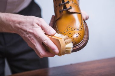 Ayakkabı kavram ve fikirler. Tan aksanlı konuşma Derby çizme için Fırça parlatma ile erkek eller closeup. Yatay atış