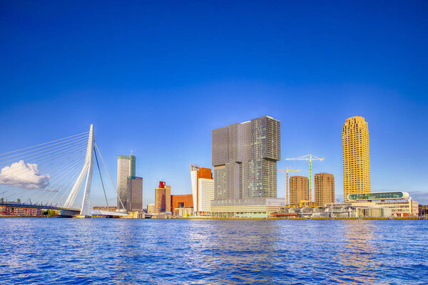 Путешествия. Amazing Sunny Cityscape View of Rotterdam Harbour and Port in front of Erasmusbrug (Swan Bridge) on Background During Daytime. Горизонтальная ориентация изображений

