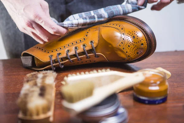 Temizlik Tan aksanlı konuşma Derby çizme temizleme aksesuarları önünde çeşitli parlatma bezi ile erkek eller closeup. Yatay görüntü yönü
