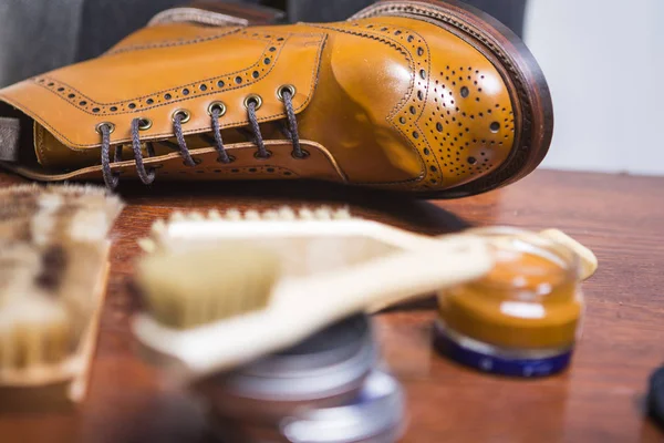 Portre erkek Tan aksanlı konuşma Derby çizme temizleme aksesuarları önünde çeşitli. Yatay görüntü yönü
