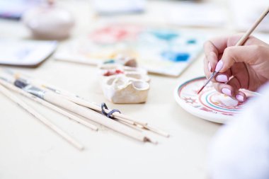 Portre, eller, kadın ustası kullanarak fırça kil el sanatları boyama için. Yatay görüntü