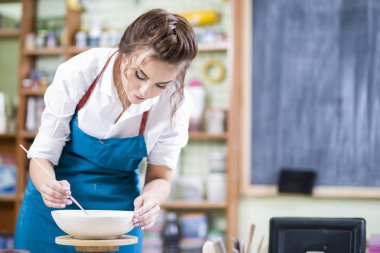 Profesyonel kadın ustası pikap atölyesinde seramik kase cam önlük portresi. Yatay görüntü