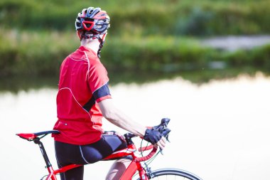 Geriye kalan doğa arka plan üzerine açık havada poz yol bisikleti olan adam. Yatay yönlendirme