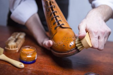 Ayakkabı Bakım. Closeup ile temizleme fırçası Tan yüksek Derby çizme parlatma için kullanılır elleri Mans. Çeşitli fırça eklendi. Yatay atış