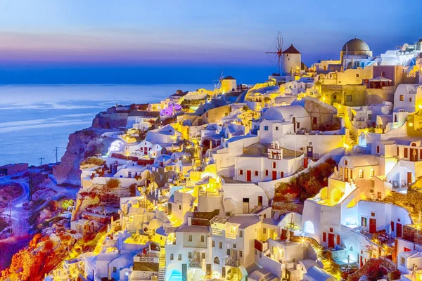 Traveling and New Destinations Concepts. Romantic Sunset at Santorini Island in Greece. Image Taken in Oia Village At Dusk. Amazing Sunset with White Houses and Windmills in Frame.Horizontal Image
