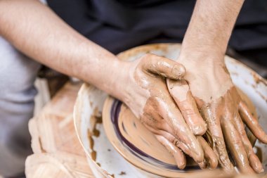Potter's tekerlek atölye ile kil yumru üzerinde kirli eller erkek closeup. Gelen her iki taraf için olsun Form ve şekil baskı. Yatay resim kompozisyon