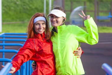 İki pozitif ve gülümseyerek beyaz Sportswomen açık kıyafet V-Sign kamera ile poz süre iyi vakit geçiriyor. Yatay görüntü