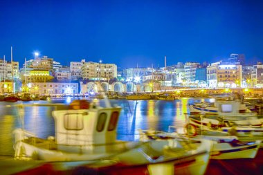 Panorama eski Venedik liman gemi ve tekneler satır ile mavi saatte Kandiye şehir Yunanistan. Ön plan üzerinde rüzgar ve dalgalar deniz nedeniyle teknelerin bulanık hareket. Yatay yönlendirme