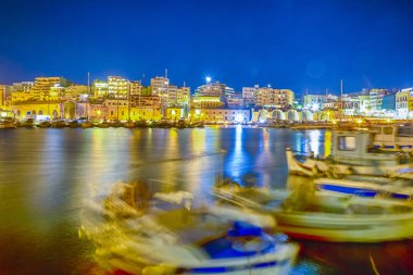 Panorama eski Venedik liman gemi ve tekneler satır ile mavi saatte Kandiye şehir Yunanistan. Ön plan üzerinde rüzgar ve dalgalar deniz nedeniyle teknelerin bulanık hareket. Yatay görüntü