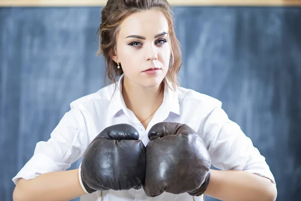 Portrait of Caucasian Female Boxer Posing in Brown Leather Boxer Gloves Against Blackboard. Horizontal Image Composition