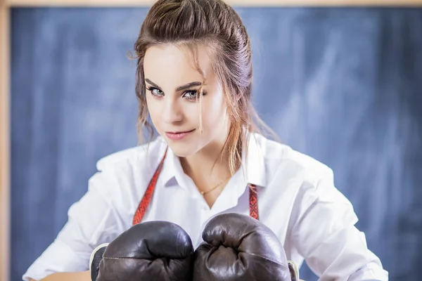 Portrait of Female Boxer Posing in Brown Leather Boxer Gloves Against Blackboard. Hands Connected Together. Horizontal Image Composition