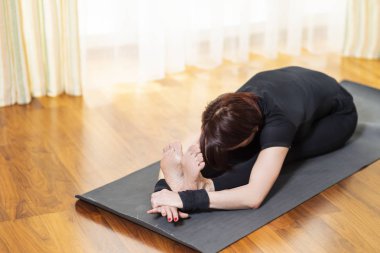 Kafkas kadın Yoga egzersiz kapalı parlak öğleden sonra itibariyle uygulamak. Pashchimottasana poz yalnızlık meditasyon oturumu sırasında oturan. En iyi siyah sütyen ve siyah Leggings.Horizontal yönlendirme