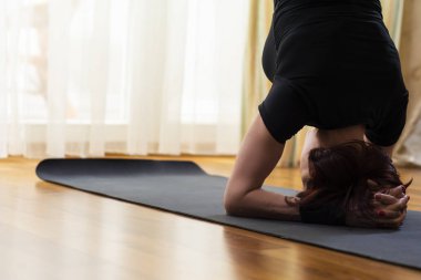 Kafkas kadın Yoga egzersiz kapalı parlak öğleden sonra itibariyle uygulamak. Shirshasana poz yalnızlık meditasyon oturumu sırasında oturan. En iyi siyah sütyen ve siyah Leggings.Vertical görüntü yönü