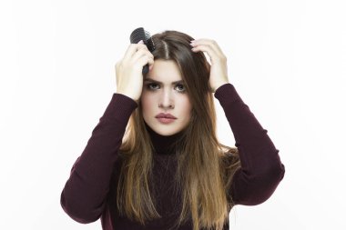 Hairloss ve kellik sorunları. Saç sorunları olan genç beyaz kadın. Saç saç fırçası içinde kontrol. Beyaz karşı. Yatay görüntü yönü