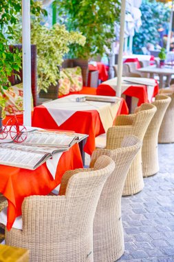 Klasik Tranquil Cretan açık hava restoran önünde Tables.Vertical görüntü orijinal hasır sandalye ile