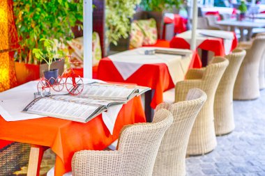 Klasik Tranquil Cretan açık hava restoran önünde Tables.Horizontal görüntü orijinal hasır sandalye ile