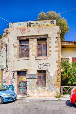 Hanya, Girit - 20 Ağustos 2018: Grunge ile eski evin önünde park etmiş iki renkli araba Hanya, duvarlarda 20 Ağustos 2018 yılında dokulu.
